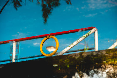 Low angle view of railing against blue sky