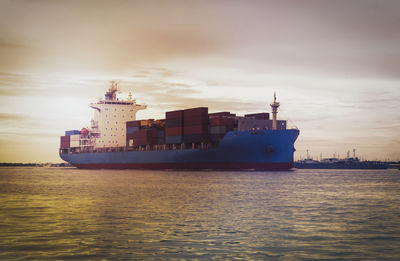 Ship sailing on sea against sky during sunset