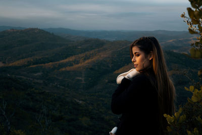 Thoughtful young woman standing at mountain