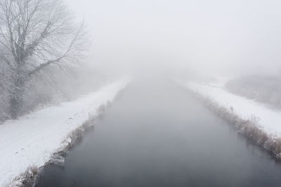 Scenic view of snow covered landscape in foggy weather