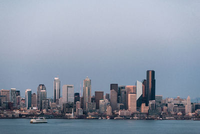 Sea and buildings against clear sky