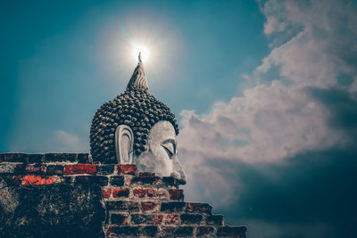 Low angle view of statue against temple against sky