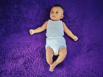 High angle view of cute baby girl on rug