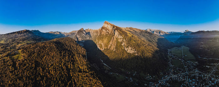 Panoramic view of landscape and mountains against blue sky
