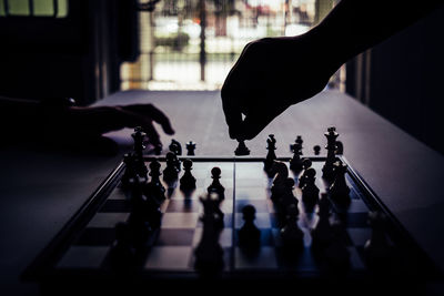 Cropped hands playing chess at table
