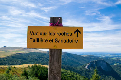 Information sign on landscape against sky