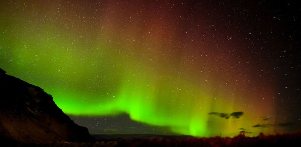 Low angle view of illuminated mountain against sky at night