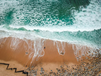 High angle view of waves splashing on beach