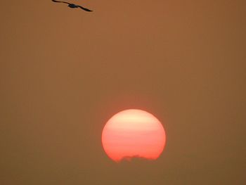 Low angle view of moon against orange sky