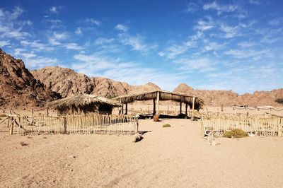 Thatched roof on desert against sky