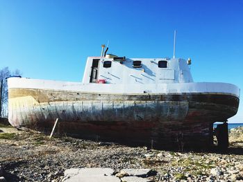 Abandoned boat against clear blue sky