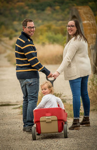 Full length parents with daughter in wagon