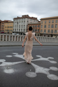 Beautiful woman dancing on road in city