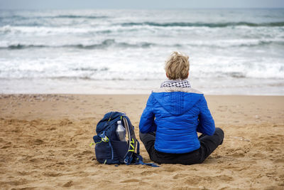 Rear view of woman standing at beach