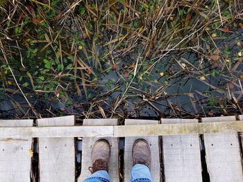 Low section of man standing on wooden floor