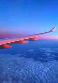 Scenic view of airplane wing against blue sky