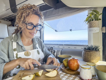Portrait of smiling young woman sitting at beach