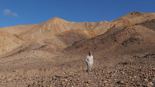 Senior man walking on mountain in the desert 