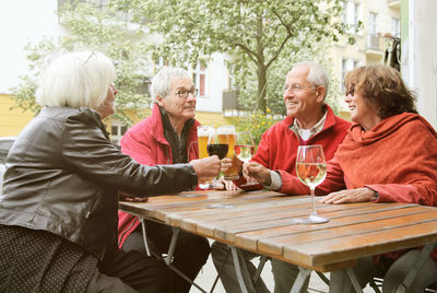 Friends sitting by table at outdoor cafe