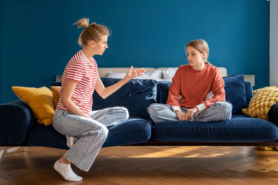 Side view of woman using digital tablet while sitting on sofa at home