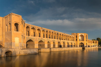 Arch bridge over river against sky