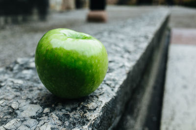 Close-up of granny smith apple on retaining wall
