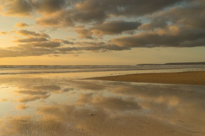 Scenic view of beach against sky during sunset