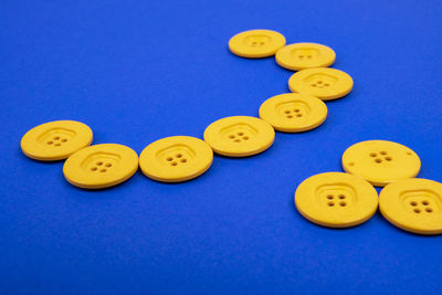 Close-up of yellow buttons against blue background