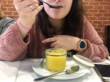 Midsection of woman holding coffee cup on table