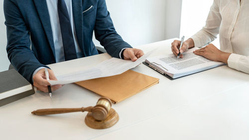 Midsection of lawyer reading book