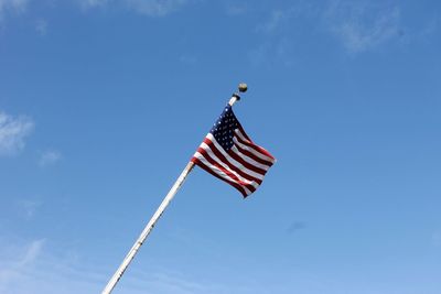 Low angle view of flag against blue sky