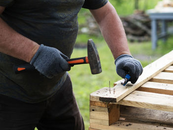 Midsection of man working on wood