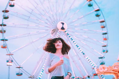 Low angle view of woman looking at amusement park