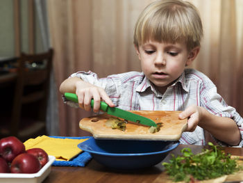 Cute boy holding food on table