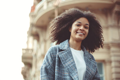 Portrait of teenager girl against building