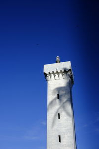 Low angle view of a lighthouse against a clear blue sky.