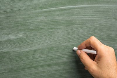 Close-up of hand holding leaf on table