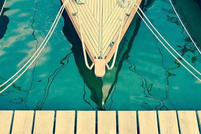 Cropped image of boat moored by jetty in river