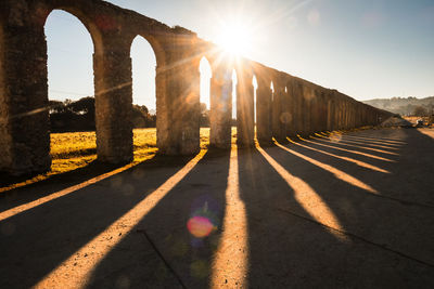 Sun shining through arch on sunny day