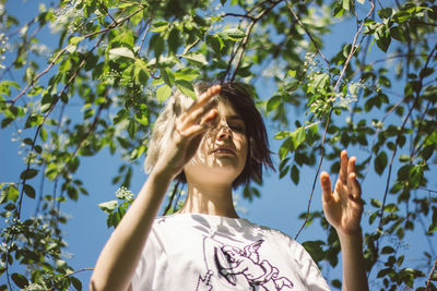 Low angle view of woman against trees