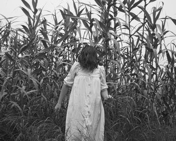 Rear view of woman standing on field