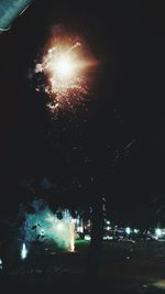 Low angle view of illuminated fireworks against sky at night