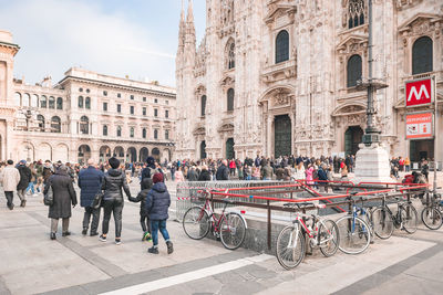 People on street against buildings in city