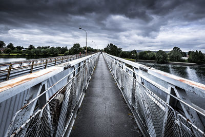 Footbridge over river against sky