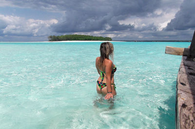 Man in sea against sky