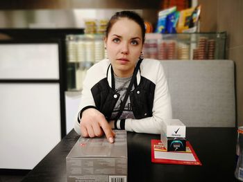 Portrait of young woman sitting on table