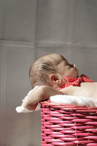 Cute baby sleeping in basket at home