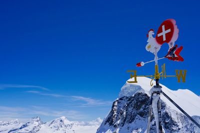 Low angle view of snowcapped mountain against blue sky