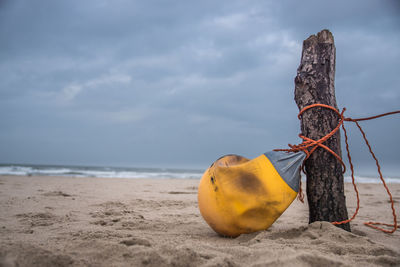 Yellow umbrella on beach against sky