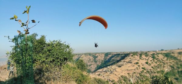 Person paragliding against sky